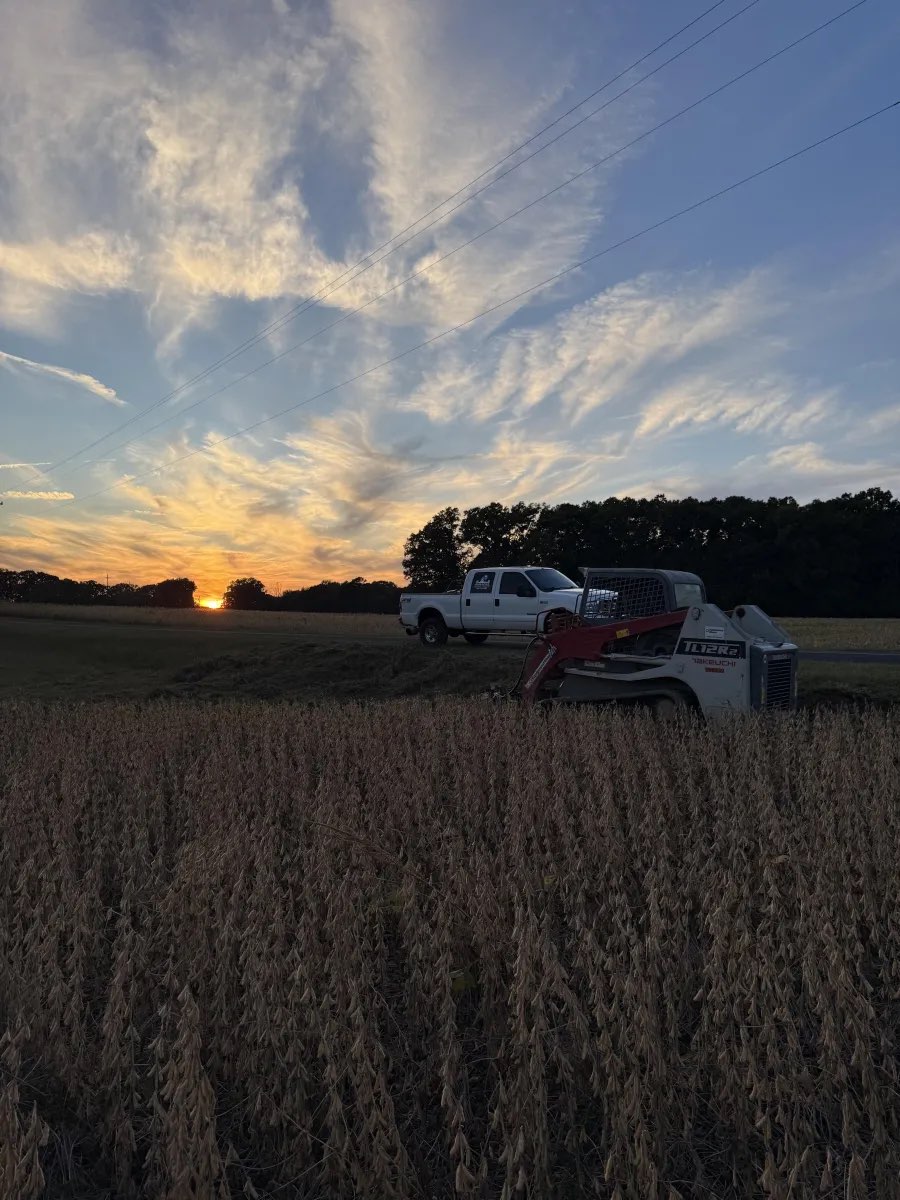 Greenpine truck and skid steer at sunset